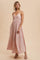 woman wearing a light pink floral maxi dress with a pleated skirt and spaghetti straps, styled with heeled sandals
