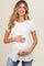 woman wearing a white short sleeve maternity top and holding her baby bump