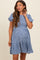 woman wearing a blue floral maternity dress with short puff sleeves and a tiered skirt