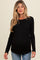 woman wearing a black long sleeve maternity top and showing her baby bump