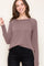 woman wearing a mauve long sleeve top with a relaxed fit and round neckline paired with black jeans