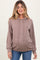 woman wearing a ribbed brown maternity hoodie with a front pocket and drawstring hood, showcasing a visible baby bump