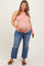 woman wearing a striped orange maternity tank top and distressed blue jeans, cradling her baby bump