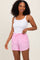 woman wearing a white lace-trimmed camisole and pink striped shorts with an elastic waistband