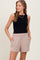 woman wearing a black sleeveless top and beige elastic waist shorts with pockets