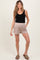 woman wearing a black maternity tank top and light beige maternity shorts with pockets