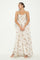 woman wearing a flowing floral maxi dress with spaghetti straps and a draped bust design
