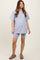 woman wearing a light gray maternity oversized t-shirt and matching shorts, showcasing her baby bump