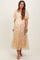 woman wearing a light gold floral midi maternity dress with puff sleeves and a tiered hem, showcasing her baby bump