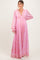woman wearing a pink floral long sleeve maternity dress with an empire waist and flowing skirt, showcasing a baby bump