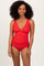 woman wearing a red scalloped edge one-piece swimsuit with a plunging neckline and a fitted silhouette