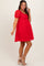 woman wearing a red maternity dress with puff sleeves and floral texture, showing her baby bump