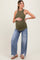 woman wearing a dark green ribbed maternity tank top and light wash wide-leg jeans, highlighting her baby bump