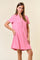 woman wearing a pink short sleeve polo dress with a button placket and a chest pocket