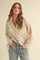 woman wearing a beige and white striped button-up shirt with two chest pockets and relaxed fit, paired with blue jeans