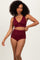 woman wearing a burgundy ribbed bikini set with a twist front top and high-waisted bottom