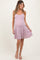 woman wearing a light pink and white striped maternity dress, showing her baby bump and smiling