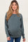 woman wearing a green long sleeve maternity sweatshirt with a relaxed fit and visible baby bump