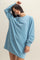 woman wearing a light blue oversized sweatshirt dress with long sleeves and a relaxed fit