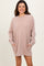 woman wearing a soft beige oversized sweatshirt dress with side pockets and long sleeves