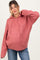 woman wearing a dusty rose maternity hoodie with cable knit sleeves and a relaxed fit, displaying her baby bump