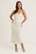 woman wearing a light floral midi dress with spaghetti straps and a fitted silhouette, posing confidently