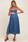 woman wearing a blue maternity maxi dress with smocked bodice and holding her baby bump
