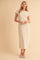 woman wearing a beige fitted midi dress with short sleeves and side slits, standing against a neutral background