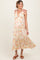 woman wearing a floral maternity maxi dress with tie shoulder straps and a visible baby bump
