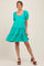 woman wearing a bright teal maternity dress with puff sleeves and tiered ruffle detailing