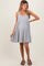 woman wearing a light gray striped maternity dress with a flared skirt and a scoop neckline, showing a baby bump