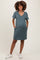 woman wearing a dark green short sleeve maternity dress with pockets and a baby bump visible
