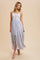 woman wearing a white floral maxi dress with thin straps and a gathered bodice