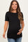 woman wearing a black ribbed maternity top with scalloped edges, smiling and showing her baby bump
