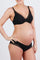 woman wearing a black maternity bra and matching briefs, showing her baby bump