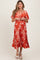 woman wearing a red and white patterned maternity dress with short sleeves and a flowy skirt