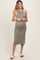 woman wearing a slim fit olive green maternity dress with white trim and a visible baby bump