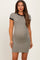 woman wearing a short sleeve grey maternity dress with black trim and showing her baby bump