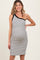 woman wearing a black and white striped one-shoulder maternity dress showing off her baby bump