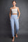 woman wearing a beige cropped tank top and light blue jogger pants with side pockets