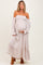 woman wearing a floral off-the-shoulder maternity gown, holding her baby bump.