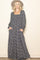 woman wearing a navy blue floral long sleeve maxi dress with a square neckline and pockets, paired with a wide-brim hat