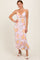 woman wearing a pink and yellow floral slip dress with a front knot detail and spaghetti straps
