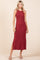 woman wearing a burgundy sleeveless maxi dress with a side slit