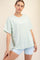woman wearing a light green oversized t-shirt and light blue athletic shorts