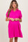 woman wearing a bright pink short sleeve maternity dress with a collared neckline and puffed sleeves