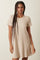 woman wearing a short sleeve ribbed beige dress with a relaxed fit and a round neckline
