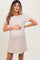 woman wearing a beige short sleeve maternity dress and holding her baby bump