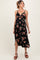 woman wearing a black floral maternity dress with a cutout detail and a flowy skirt, showcasing her baby bump