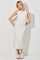 woman wearing a cream sleeveless midi dress with a striped pattern and white sneakers